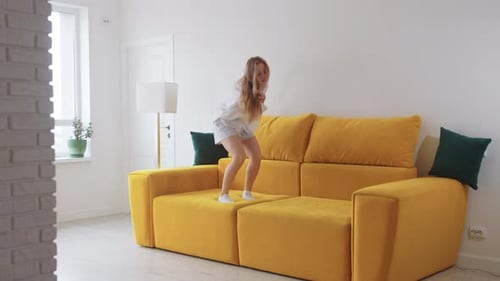 Young Skinny Woman Dancing on Yellow Couch