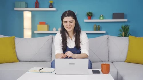 Frau, die auf den Laptop schaut, ist glücklich und tanzt.