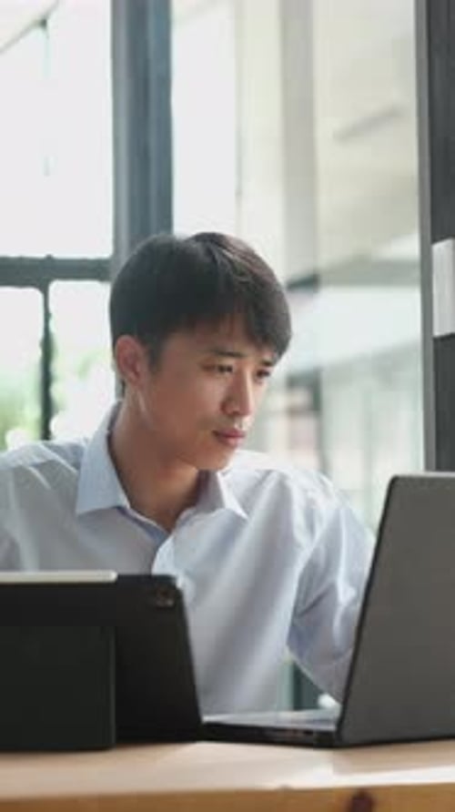 Young Adult Working on a Laptop in Office