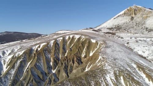 Snowy Mountain Peak with Eroded Ridges Under Blue Sky