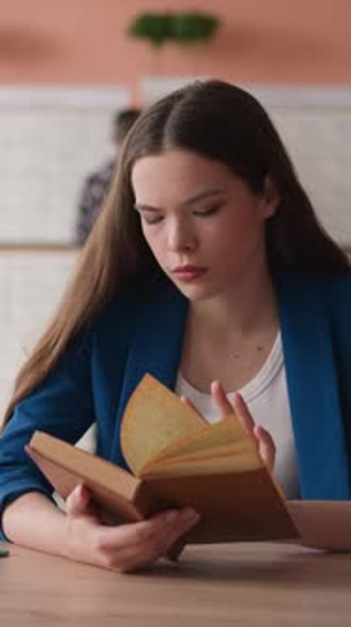 Young Woman Engrossed in Book at Table