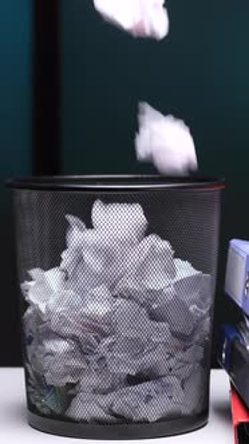 Vertical Video Crumpled Paper Falling Into Full Office Waste Basket