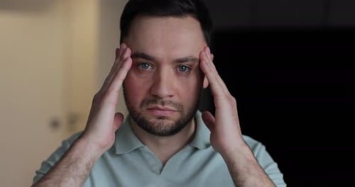 Man Massaging Temples in Close Up