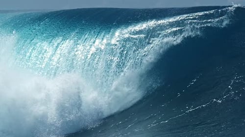Perfect blue ocean wave breaks on the shore in the Maldives.