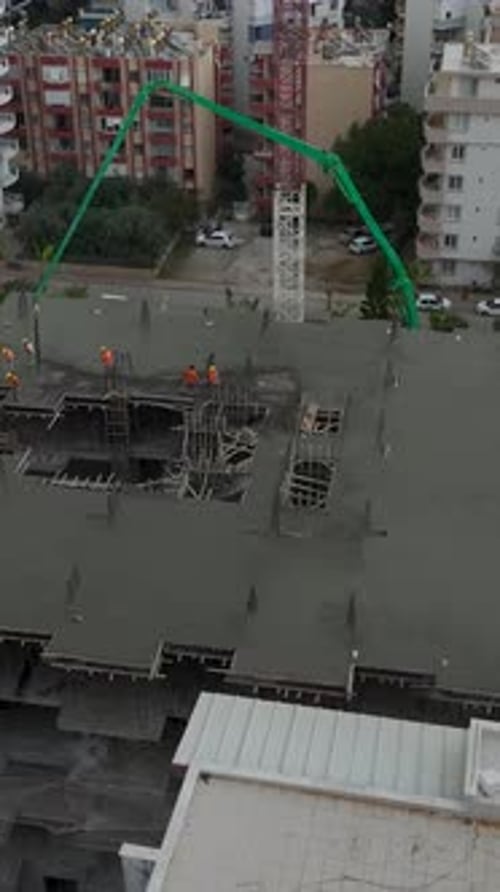 Vertical Video Residential Highrise Foundation Construction in Action As Workers Pour Concrete