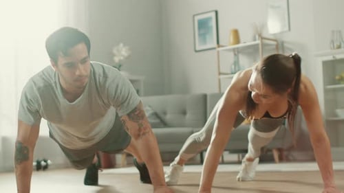Fit Couple Doing Pushups in Living Room
