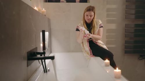 Woman Relaxing in Candlelit Bath at Night