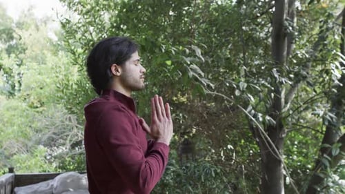Man Meditating Outdoors in Green Natural Setting