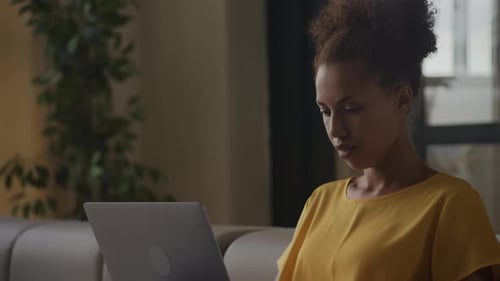 Close Up African American Thoughtful Woman Thinking on a Decision While Working on a Laptop Indoors