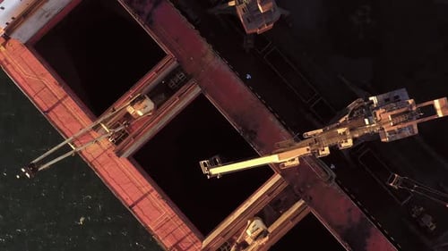 Industrial Cranes Transporting Coal on the Tanker Ship