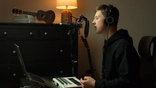 Young man recording at home studio, passionately singing into a professional microphone