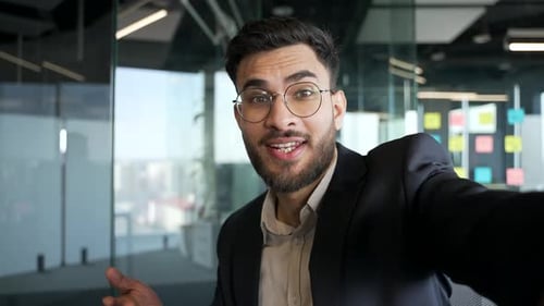 POV Happy businessman in formal suit talking on video call using phone in the office. Handsome