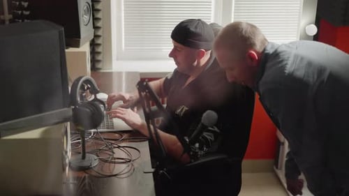 Deux hommes collaborant dans un studio avec équipement d'insonorisation et d'enregistrement