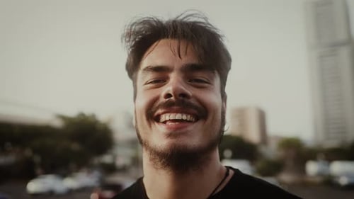 Happy young man smiling in front of camera in the city