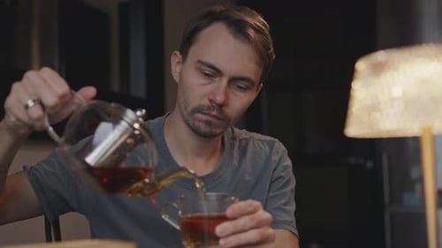 Atmosphère chaleureuse Un homme se sert du thé à une table