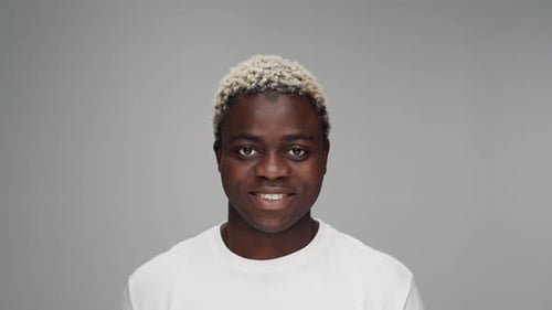 Man Smiling In Front Of Grey Background