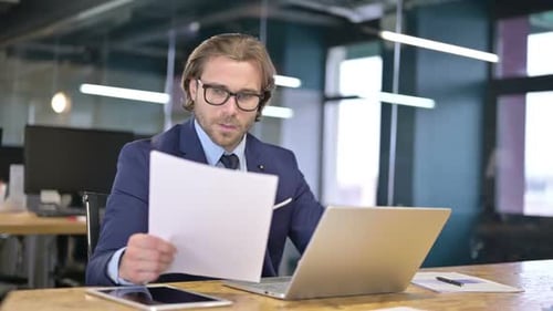 The Businessman Reading Documents on Office Desk