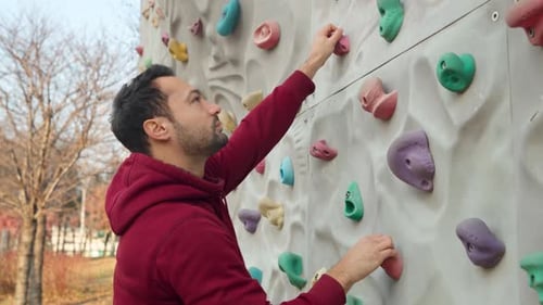 Sporty Man Climber Climbs a Climbing Wall - close-up