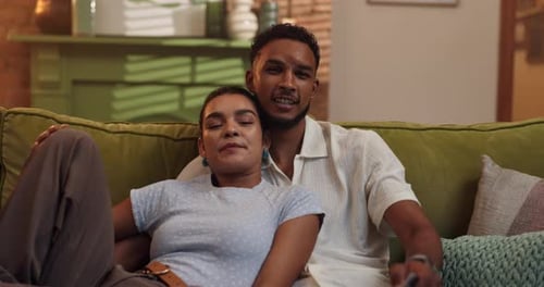 Smiling Couple Relaxing on Couch with Remote Control