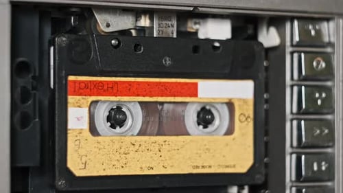 Audio Tape Recorder Playback Insert and Eject Yellow Audio Cassette CloseUp