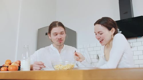 Young Couple Having Breakfast Together in Modern Kitchen