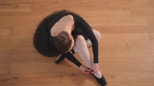 Ballerina Puts on Pointe Shoes on Leg in Dance Class Classical Ballet Dancer Woman in Dance Studio