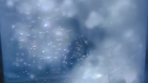 Close up motion stacked ice cubes collapsing with bubbles underwater