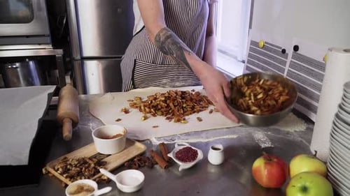 Baker Spreads Apple Filling on Strudel Dough