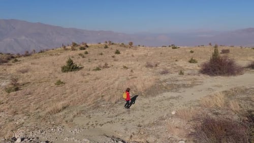 Aerial View Young hiker walking on a mountain path on a sunny day