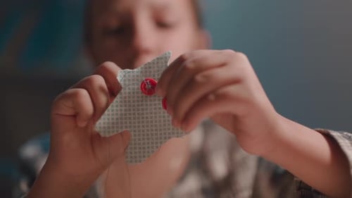 A Schoolage Girl Makes a Craft with Her Own Hands in Her Room at Home