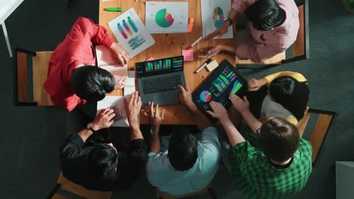 Team Brainstorming Data and Graphs at Meeting Table
