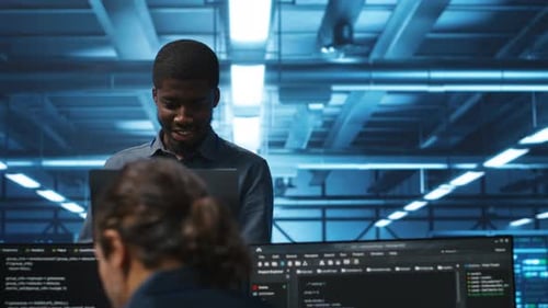 Jolly Supervisor Oversees Technicians in Data Center Mending Supercomputers