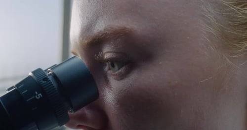 Close Up of Eyes of Female Doctor Looking Under Microscope