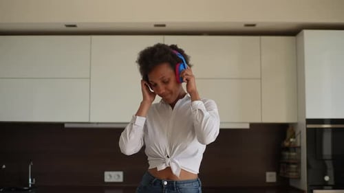 Woman Dancing to Music in Bright Kitchen