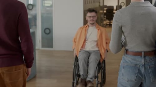 Office Workers Greeting Colleague in Wheelchair