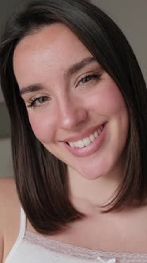 Vertical video, Close up of Happy Young Woman Smiling in Bedroom