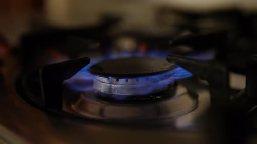 Closeup View of Gas Stove Burner Emitting Bright Blue Flame Indicating Efficient Combustion and