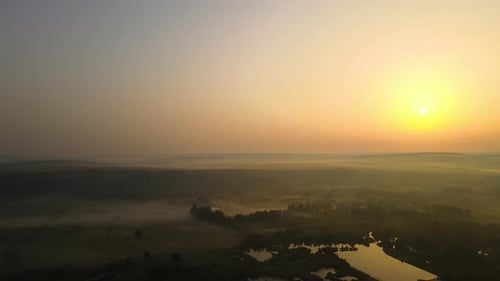 Aerial Landscape View of Sunny Morning Over Foggy Green Fields