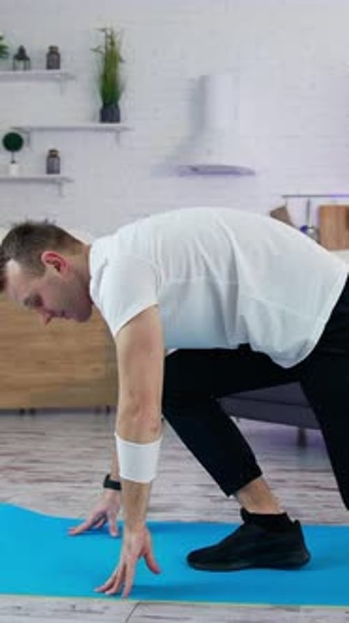 Man on Yoga Mat Stretching at Home
