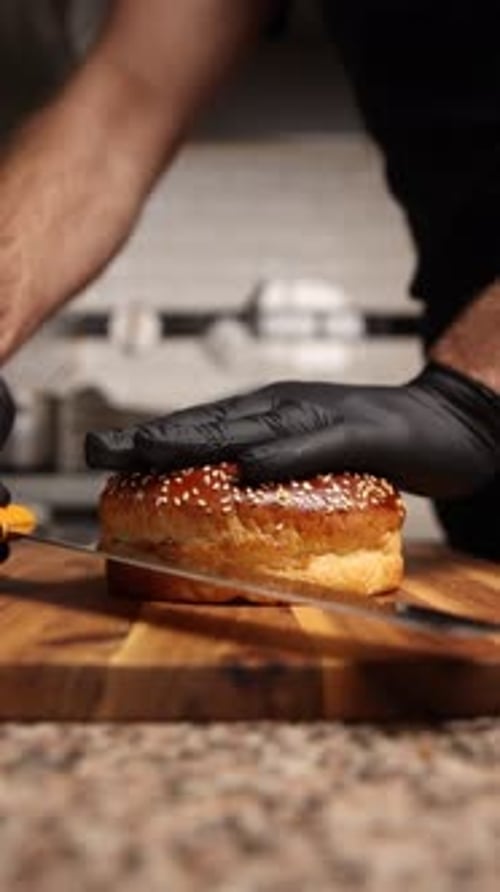Chef Cuts Sesame Seed Burger Bun in Half