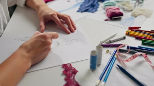 Fashion Designer Sketching Dress Design with Art Supplies