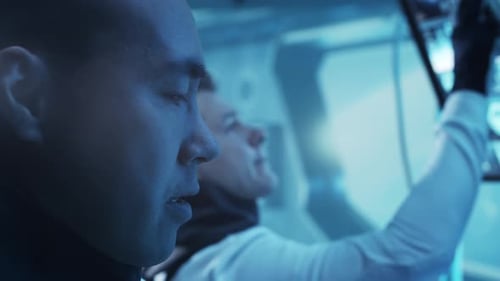 Team of Astronauts in a Space Suits Aboard the Orbital Station A Crew of Cosmonauts Piloting the