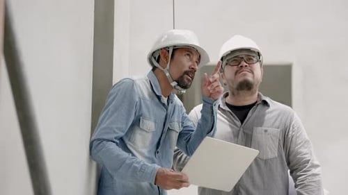 Indian architect with mustache talking with engineer foreman Planning an addition to the home's stru