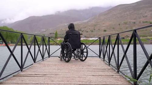 Man in a wheelchair near the lake