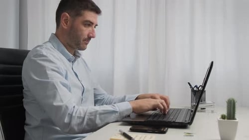 Adult Male Working on Laptop Computer at Desk
