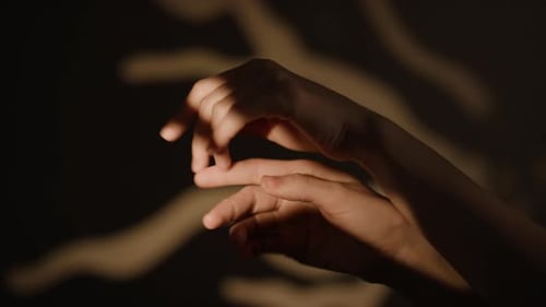 Close-up of Female Hands Softly Moving in Semi-darkness