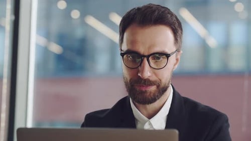 Man Working on Laptop in Modern Office