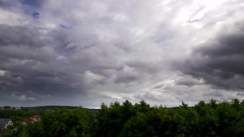 Timelapse of rain clouds moving on a blue sky.