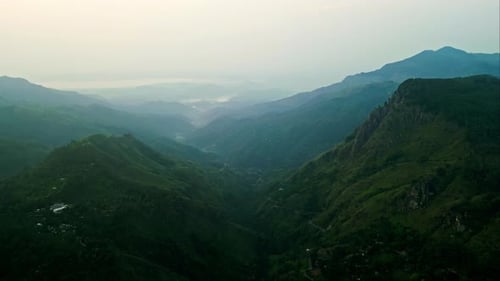 O nascer do sol banha os vales do topo das montanhas de Ella com brilho. Os madrugadores testemunham o amanhecer Serene Highland