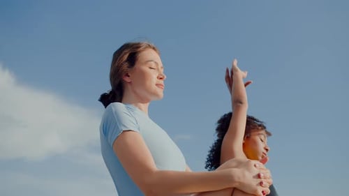 Women Practicing Yoga and Stretching on Sunny Day
